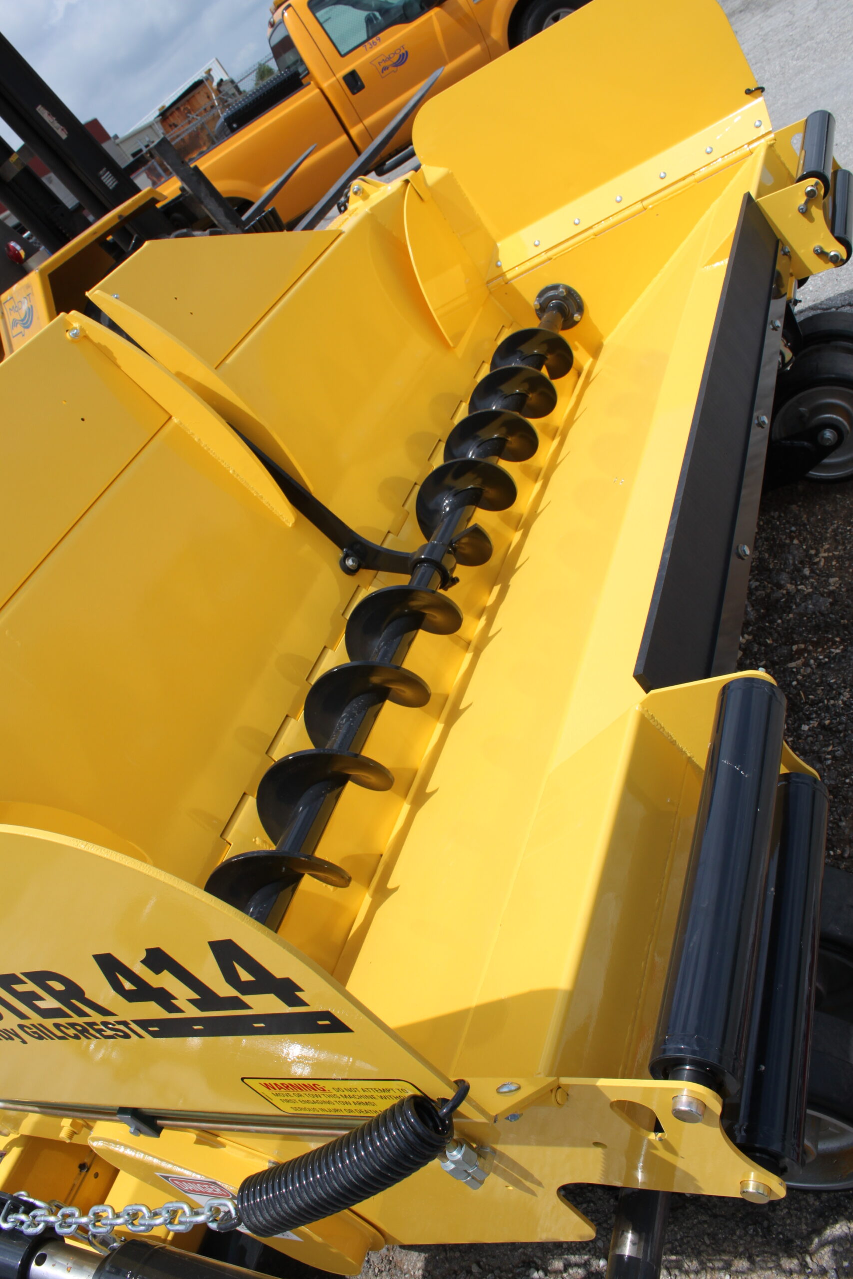 Close-up image of a yellow machine with a hydraulic arm, emphasizing its engineering and operational capabilities.