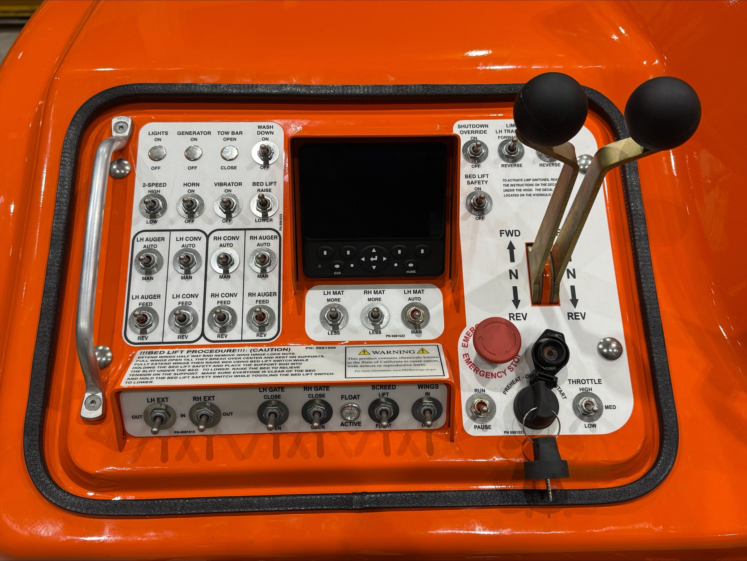 Detailed view of an orange machine, highlighting its buttons and knobs, emphasizing its operational features.