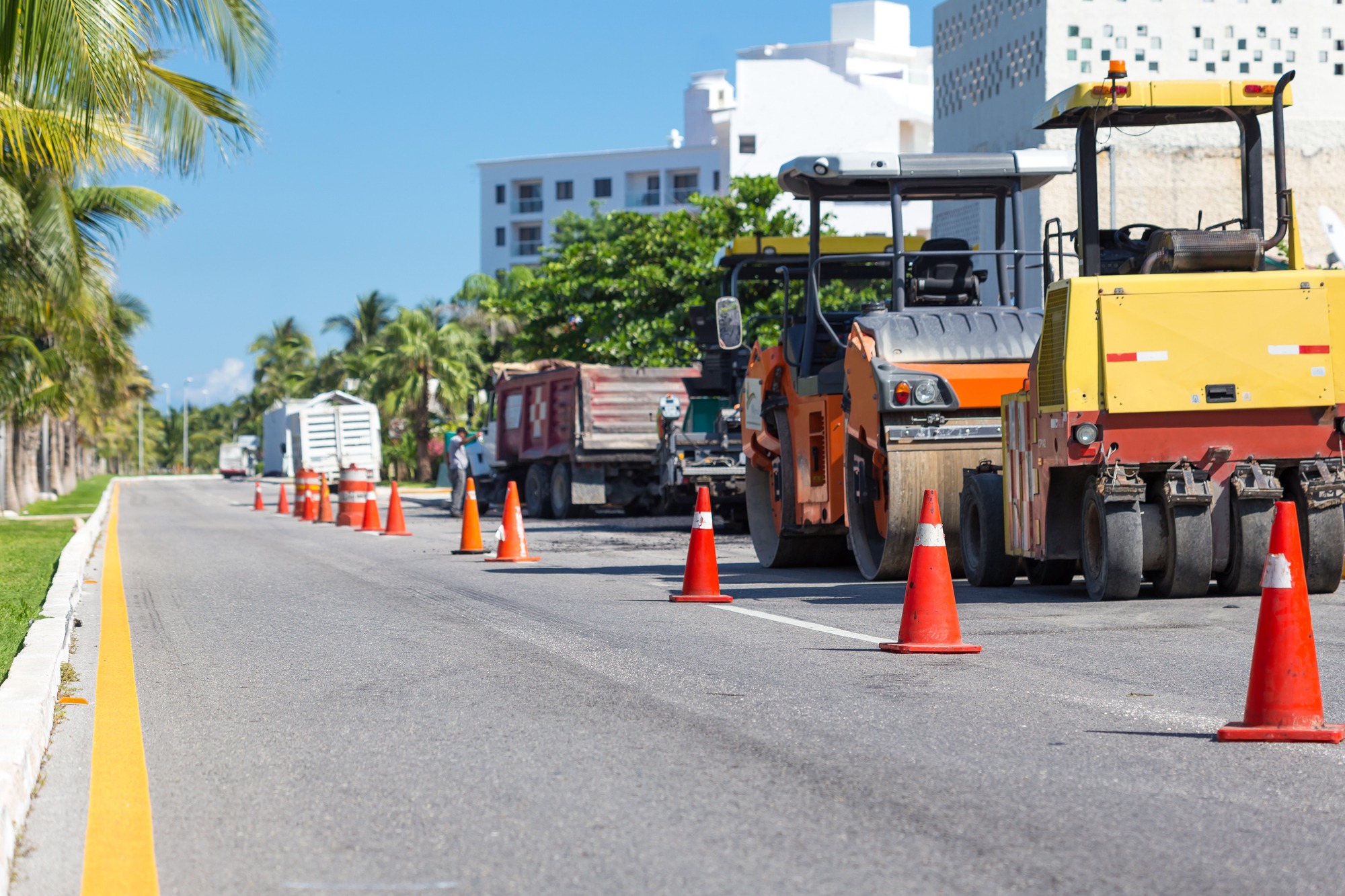 Road construction works. Traffic cones at tropical street warning about asphalt pavement works