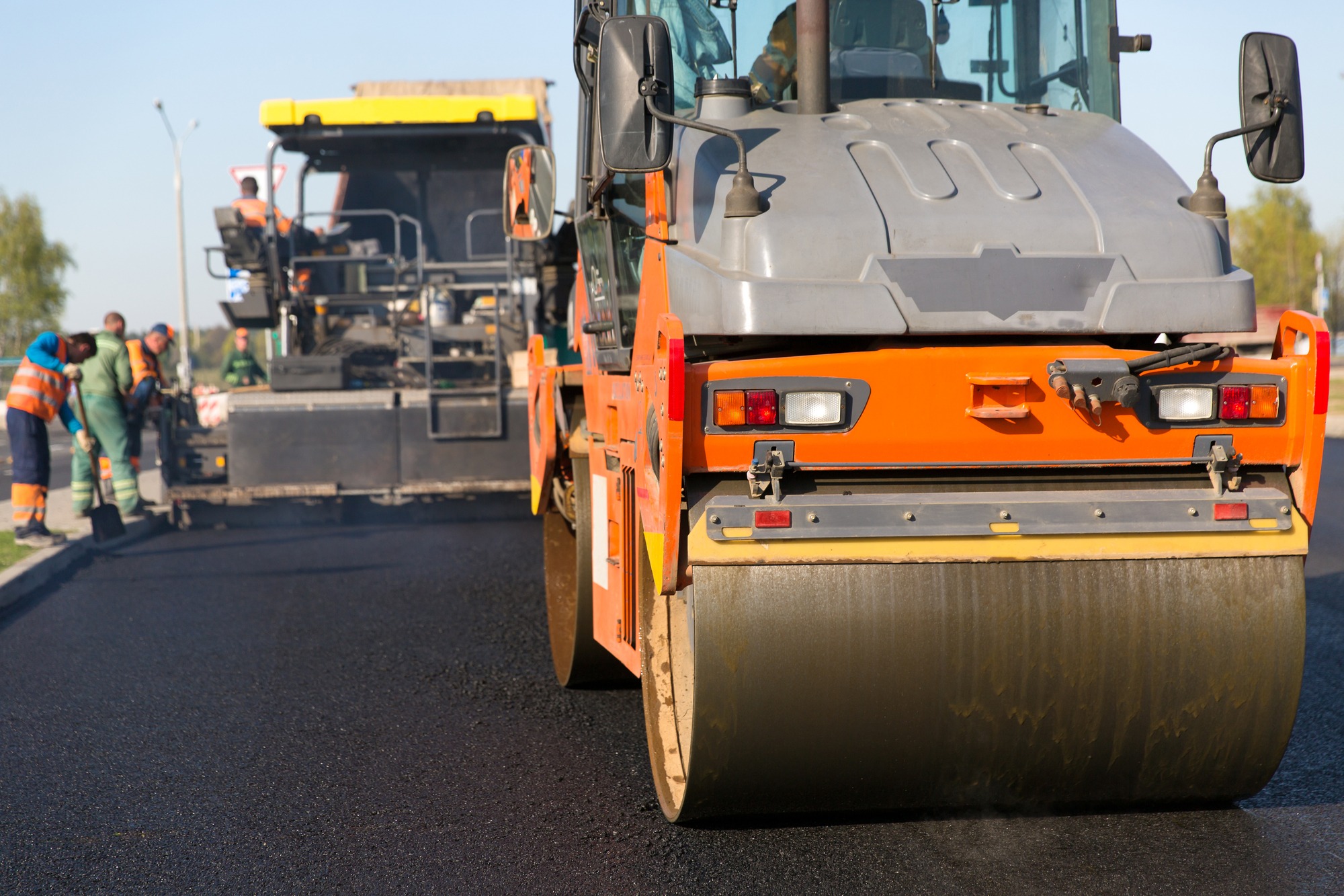 Road construction works with roller compactor machine and asphalt finisher